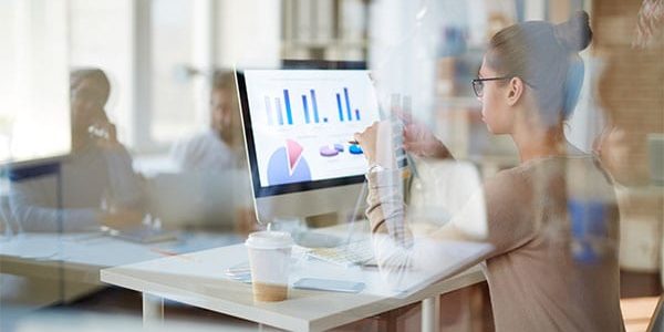 Contemporary businesswoman looking at computer screen with data